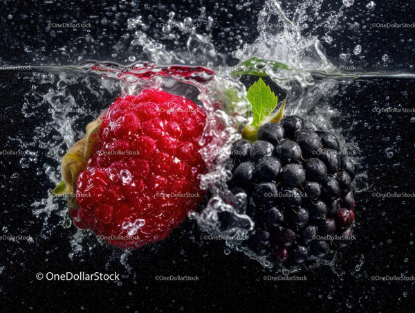 Fresh Raspberries and Blackberries Splashing in Water