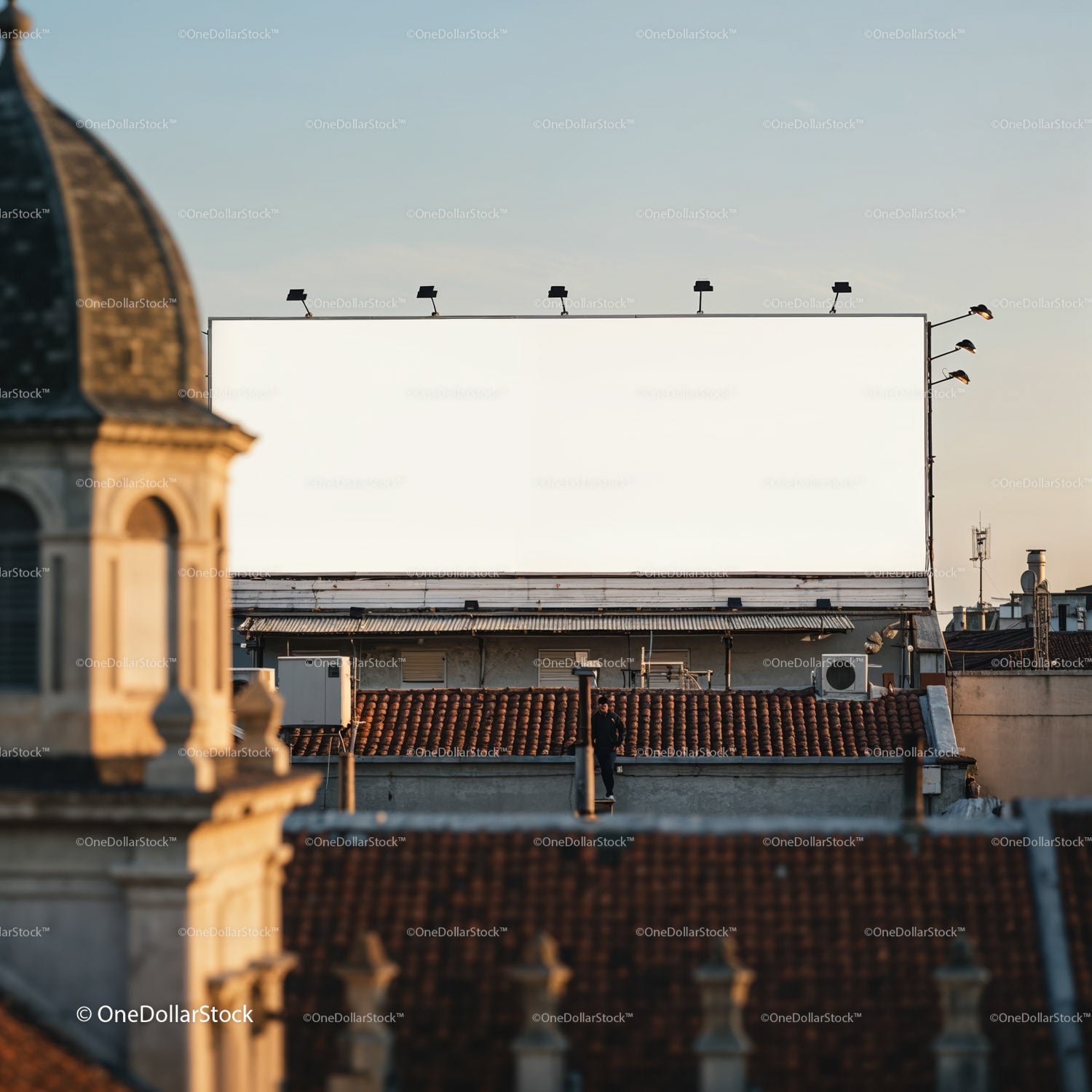 Pusty, duży billboard nad dachami miast o zachodzie słońca