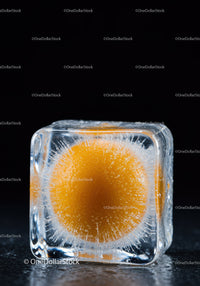Orange sphere frozen inside a clear ice cube block