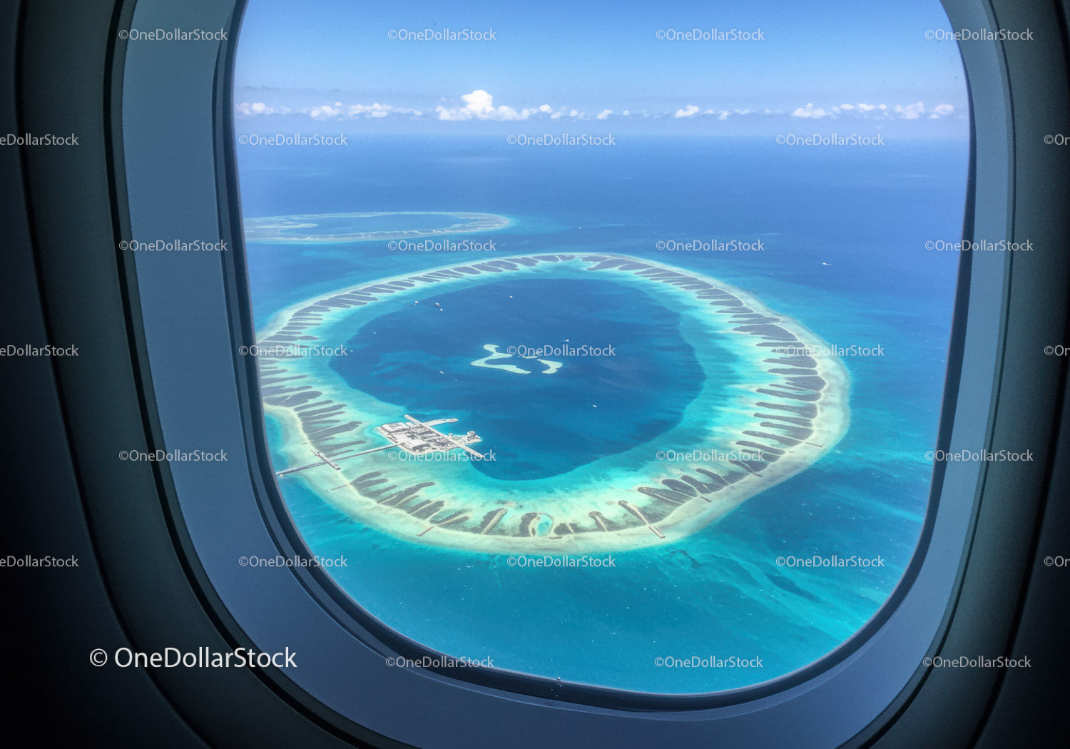 Aerial View of a Circular Lagoon Island with Beach Resort and Turquoise Waters