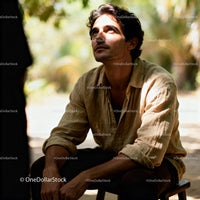 Pensive man sitting outdoors in warm sunlight