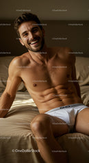 Smiling young man relaxing shirtless on bed in white briefs