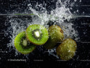 Fresh Kiwi Slices Splashing into Water with Bubbles