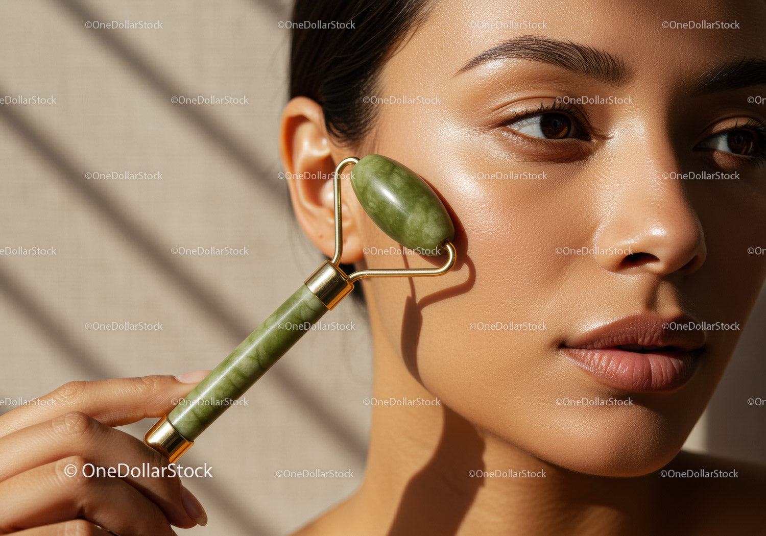 Close-up of a woman using jade roller on face for skincare and facial treatment