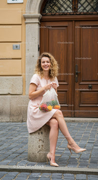 Smiling woman sitting outdoors with fresh groceries