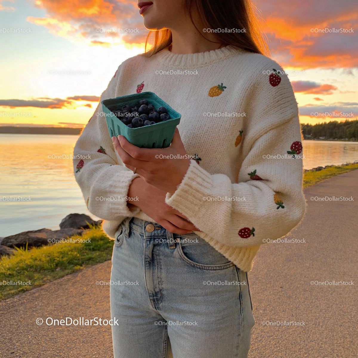 Woman Holding Fresh Blueberries at Lakeside Sunset