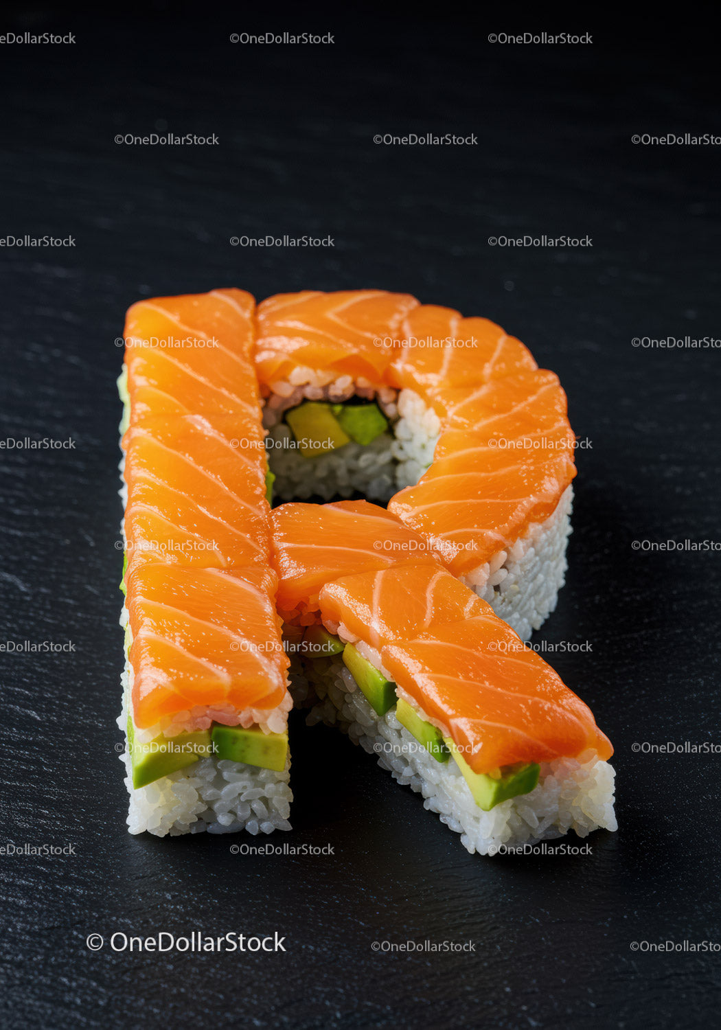 Sushi z łososiem i awokado w kształcie litery R na czarnym łupku