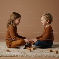 Two children playing with wooden blocks on knitted rug