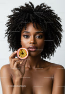 Portrait of a Black Woman with Curly Hair Holding Passion Fruit