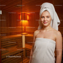 Young Woman Relaxing in Warm Sauna with Towel Wrapped Hair Indoor