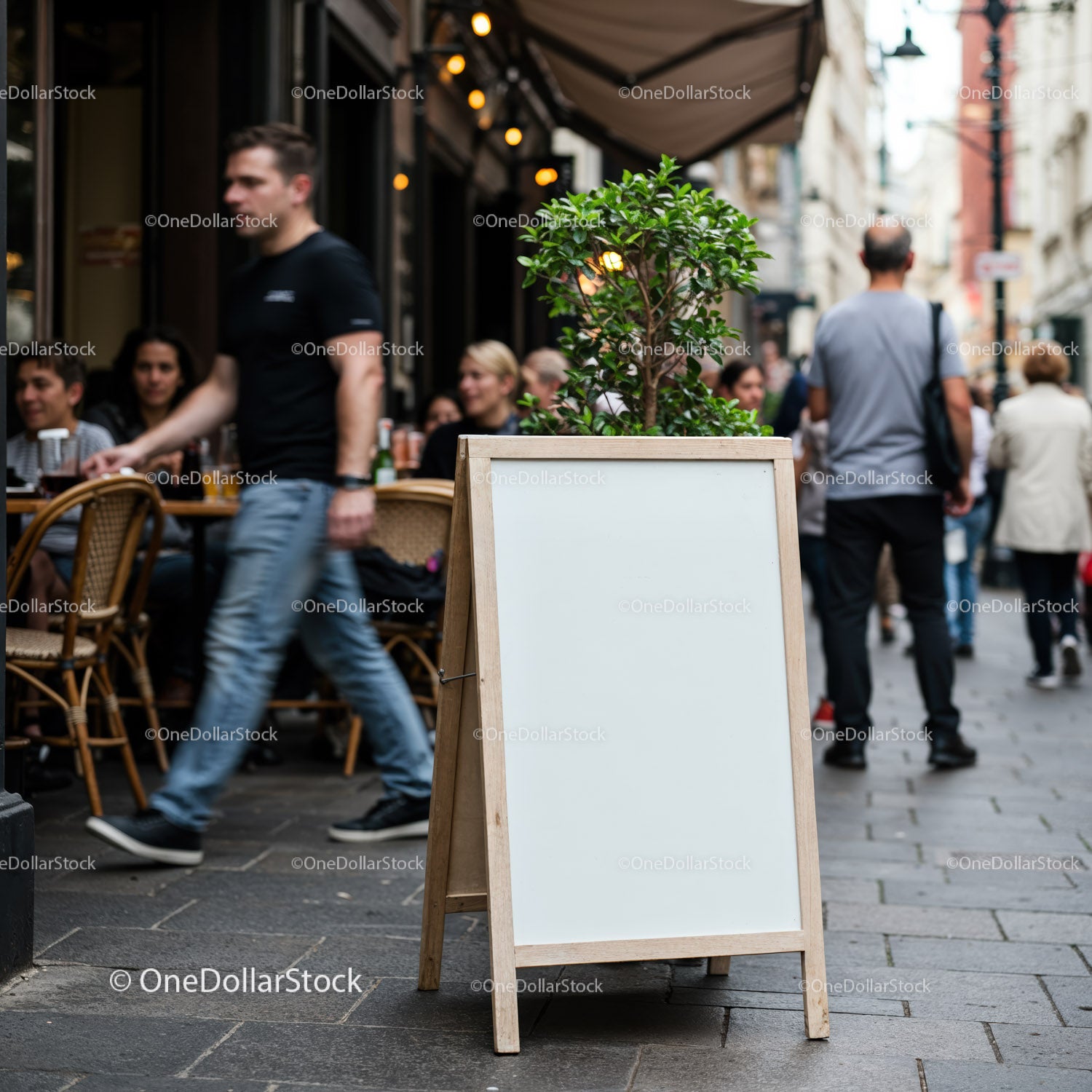 Busy street cafe with blank sidewalk signboard