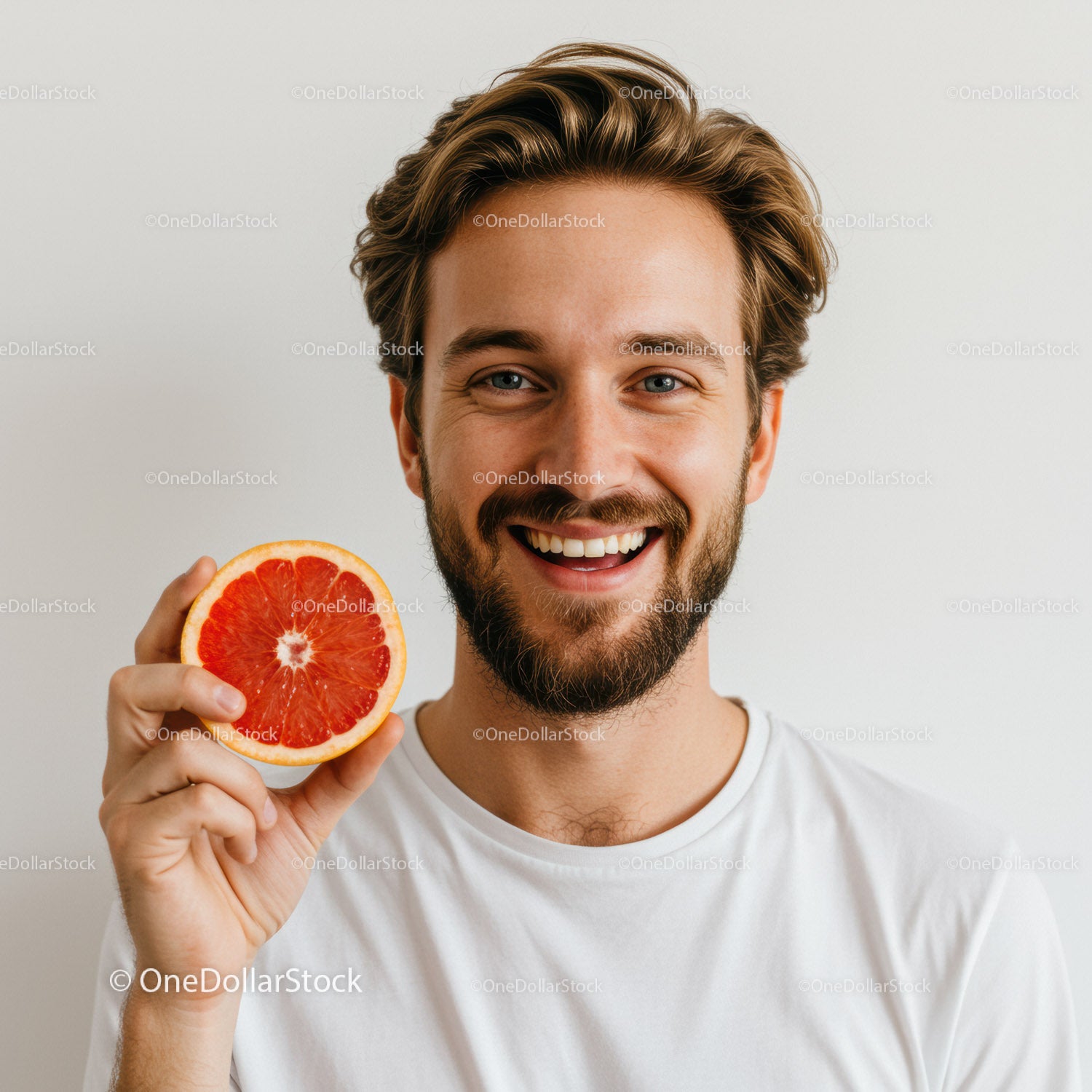 Happy Man Holding Fresh Red Grapefruit Slice for Healthy Lifestyle