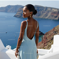 Elegant woman in light blue dress overlooking sea view