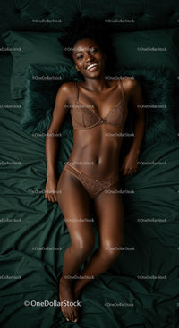 Smiling woman relaxing on dark green bed linen