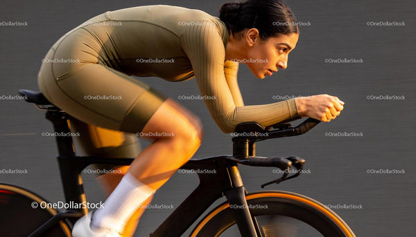 Focused female cyclist training intensely on modern bike