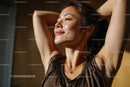 Joyful Woman Relaxing in Sunlight with Closed Eyes and Peaceful Expression