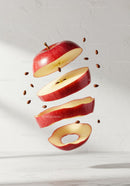 Red apple slices and seeds floating in mid-air