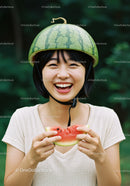 Young woman wearing watermelon helmet and eating slice