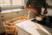 Parent cooking in kitchen with sleeping baby nearby