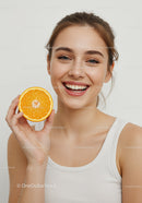 Young Woman Smiling Holding Fresh Orange Slice for Healthy Lifestyle
