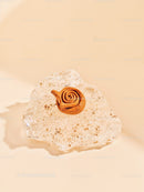 Unique rose-shaped clay sculpture on textured glass