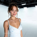 Young Woman in White Dress Smiling in Studio with Gentle Lighting