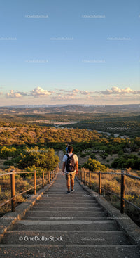 Young Man Hiking Down Mountain Trail During Golden Hour