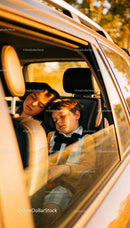 Two children peacefully sleeping in car during sunset