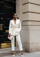 Confident woman in elegant white suit with gold accessories
