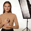 Young woman holding her pet hamster in cozy studio