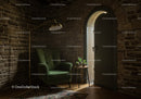 Cozy corner with green armchair and stone walls