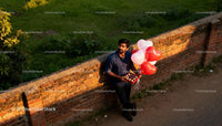 Man Holding Heart Balloons and Chocolates Outdoors