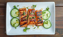 Grilled Salmon with Cucumber Slices and Fresh Herbs on White Plate
