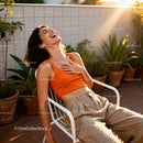 Joyful young woman laughing outdoors in warm sunlight