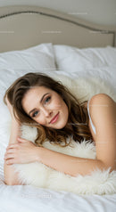 Young woman lying peacefully on soft bed pillows