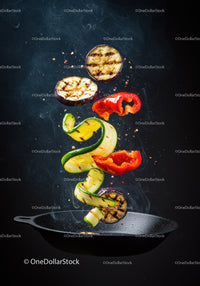 Grilled Vegetables Tossed in Air Over Black Pan