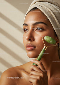 Beautiful Woman Receiving Facial Massage with Jade Roller in Natural Setting