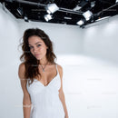 Young Woman in White Dress in Studio with Bright Lighting