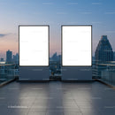 Two blank billboards on rooftop with city skyline