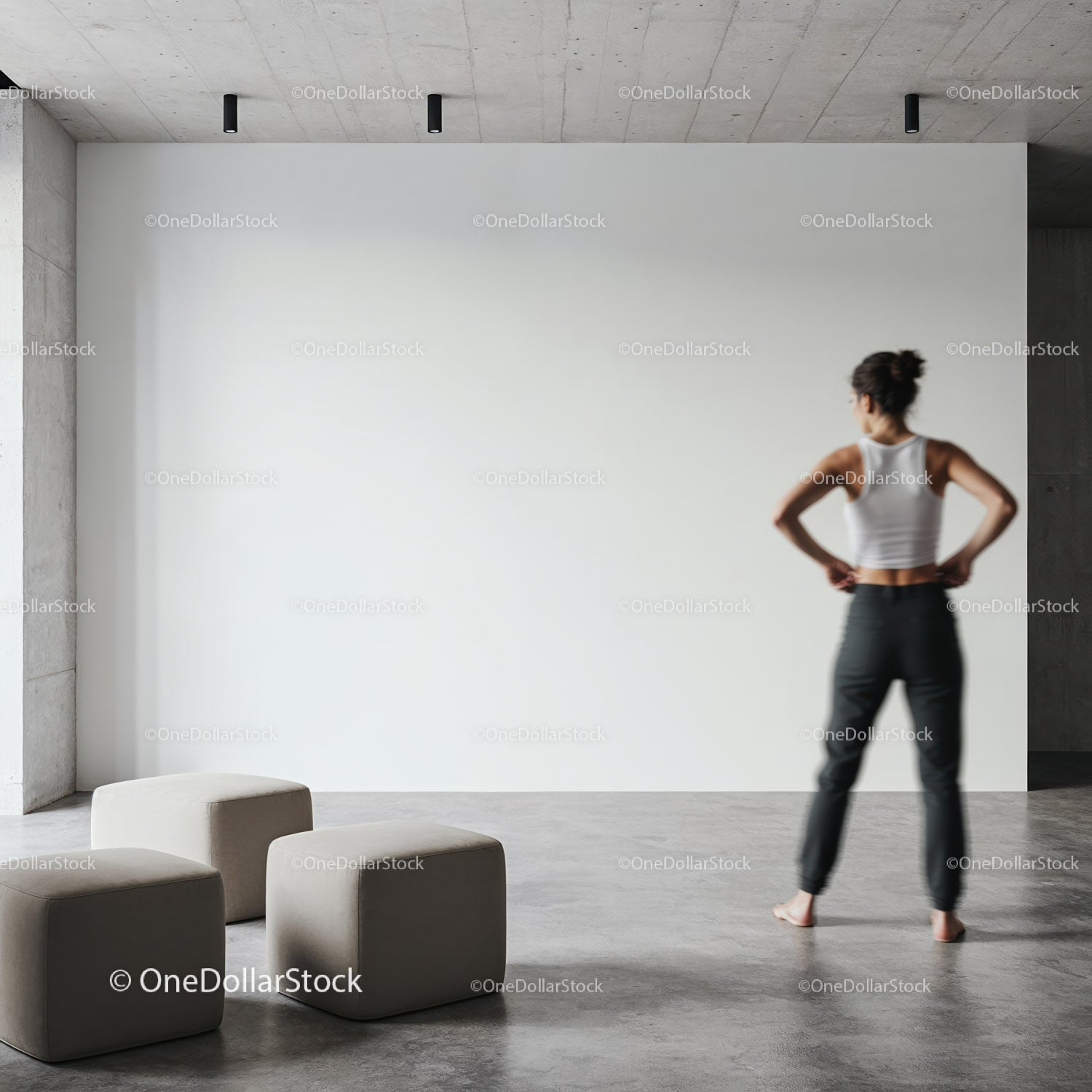 Woman contemplating blank wall in modern minimalist room