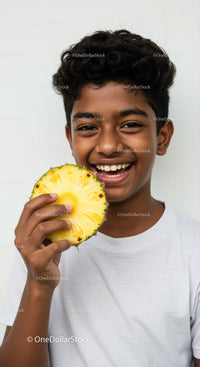 Young Boy Enjoying a Slice of Fresh Pineapple with a Bright Smile