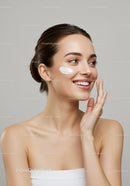 Young Woman Applying Skincare Cream for Healthy Radiant Skin