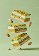 Three Pistachio Dessert Bars Floating on Green Background