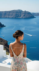 Woman in floral dress overlooking calm sea and cliffs