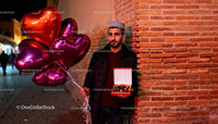 Man Holding Heart-Shaped Balloons With Chocolates Gift Box