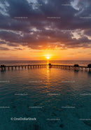 Beautiful Sunset Over Ocean with Pier and Cloudy Sky