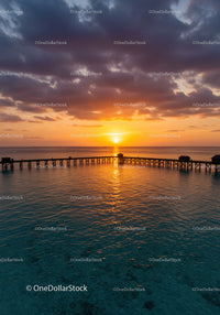 Beautiful Sunset Over Ocean with Pier and Cloudy Sky