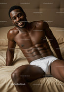Smiling muscular man relaxing on bed in white briefs