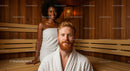 Happy Young Couple Relaxing in Sauna During Wellness Session