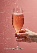 Woman holding sparkling rose wine glass with bubbles